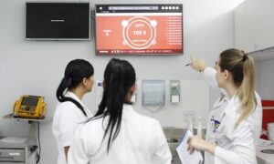 Health care professionals monitor Laura's data on screen